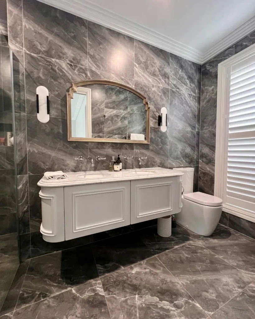 Bathroom with curved double vanity and marble-look tile