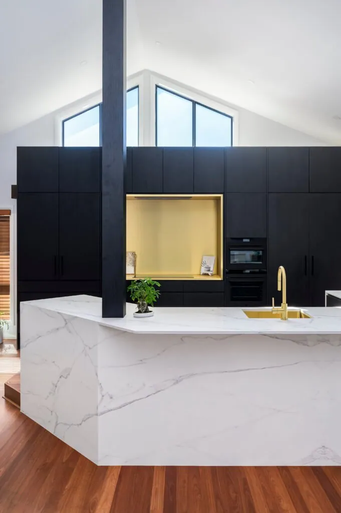 Dark joinery with brass-lined niche beneath a raked ceiling